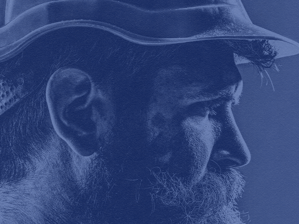 A photo of a crew member side profile with a hard hat on.