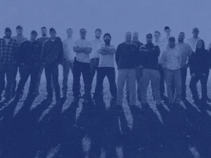 A photo of a group of crew members standing shoulder to shoulder looking at the camera.