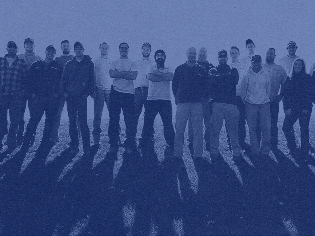 A photo of a group of crew members standing shoulder to shoulder looking at the camera.