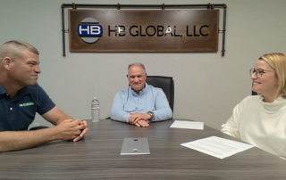 A photo of Bob Whalen, John Saich, and Stacy Baum (left to right) sitting around a conference table recording the podcast.