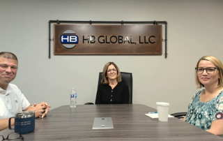 A photo of Bob Whalen, Chris Sears, and Stacy Baum (left to right) sitting around a conference table to record the podcast.