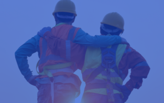 A photo of two construction workers with their backs to the camera and their arms over each other’s shoulders. There is a blue overlay on the picture.